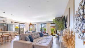 Una sala de estar moderna con sofá, comedor y cocina.