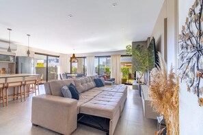 Ein modernes Wohnzimmer mit Sofa, Essbereich und Küche.