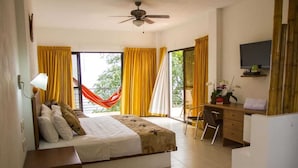 Habitación de hotel con cama, escritorio, silla y televisor.