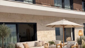 Un espacio al aire libre moderno con piscina, mobiliario exterior y plantas en macetas.