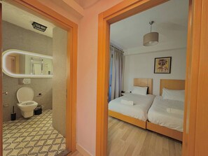 Ein Hotelzimmer mit Bad, einem Bett, einem Spiegel und einem Gemälde.