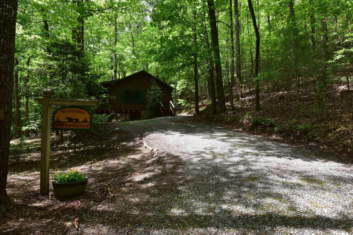 A gravel path leading to a cabin labeled 'Bear Cove' in a forested area.