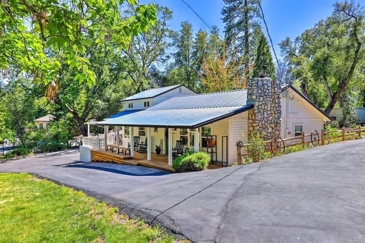 A house with a stone chimney, a covered porch, and a garage.