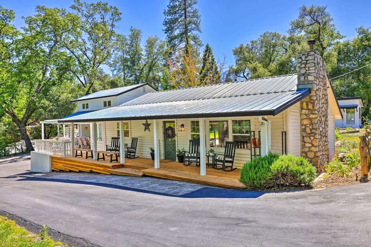 Une maison de plain-pied avec un porche, une cheminée en pierre et une petite terrasse.