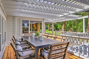 An outdoor patio with a wooden table and chairs, a pergola, and a view of the surrounding greenery. - Sprawling Murphys Farmhouse|Walk Dwntwn|Ping Pong! (Arnold)