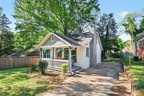 A single-story house with a front porch, a chimney, and a backyard. - Cozy Atlanta Home Minutes from Amphitheater, Downtown, Stadium & Attractions (Atlanta)