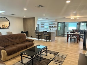 Ein modernes Wohnzimmer mit einer Couch, einem Couchtisch und einem Essbereich mit Stühlen und einem Tisch.
