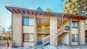 A two-story building with a balcony, a staircase, and a door. - Cozy Corner Condo with Shared Pool and Hot Tub, Close to the Lakes & Ski Resort (Mammoth Lakes)