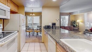 A kitchen with a stove, microwave, refrigerator, and granite countertop. - Cozy Corner Condo with Shared Pool and Hot Tub, Close to the Lakes & Ski Resort (Mammoth Lakes)