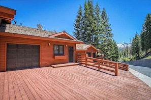 A wooden cabin with a garage, a wooden deck, and a mountain backdrop. - Mammoth Lakes getaway - walking distance to the slopes (Mammoth Lakes)