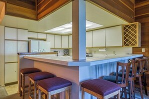 A kitchen with a central island, bar stools, wooden chairs, and a wine rack. - Mammoth Lakes getaway - walking distance to the slopes (Mammoth Lakes)