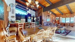 Amplia sala de estar con una mesa de comedor de madera y sillas, un sofá y una araña.