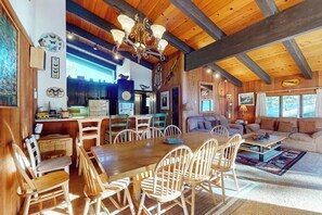 A spacious living area with a wooden dining table and chairs, a sofa, and a chandelier. - A Peaceful Destination in Mammoth Lakes (Mammoth Lakes)