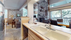 Una cocina moderna con una isla grande, una pared decorativa de piedra y un comedor con vistas.