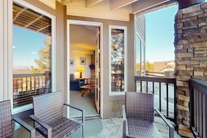 Ein Balkon mit Korbstühlen, einer Steinwand und Blick ins Innere.