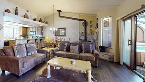 A living room with sofas, a coffee table, and a fireplace. - Townhome-Style Property with Private Hot Tub and Gorgeous Forest Views (Mammoth Lakes)