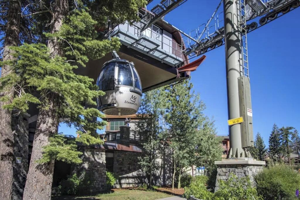 Un téléphérique doté d’une cabine sphérique, d’un bâtiment en pierre et d’un poteau électrique.