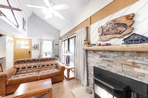 A living room with a sofa, fireplace, and a ceiling fan. - Cozy Studio with a Loft, Shared Swimming Pool, Hot Tub, and Sauna (Mammoth Lakes)