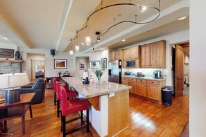 A spacious kitchen with wooden cabinets, a granite countertop, and a central island with bar stools. - Enjoy this Beautiful Lodge Near the Golf Course, Athletic Club, & the Slopes (Mammoth Lakes)