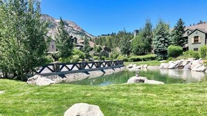 A bridge over a pond, surrounded by greenery and houses. - Enjoy this Beautiful Lodge Near the Golf Course, Athletic Club, & the Slopes (Mammoth Lakes)