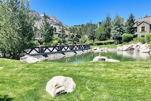A bridge over a pond, surrounded by greenery and houses. - Enjoy this Beautiful Lodge Near the Golf Course, Athletic Club, & the Slopes (Mammoth Lakes)