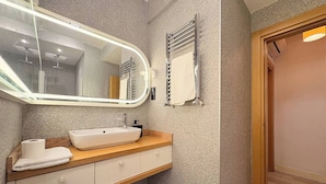 A bathroom with a large mirror, a sink, a towel, and a shower area. - Taksim Square1br Suite 02 (Istanbul)