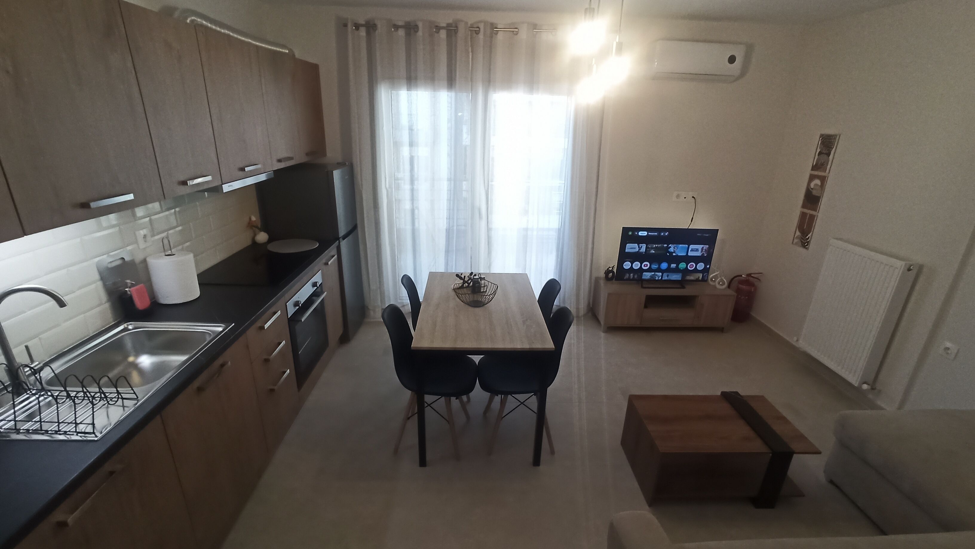 Une cuisine compacte avec un coin repas, un téléviseur et un radiateur.