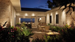 Eine moderne Außenpatio mit Essbereich, Feuerstelle und Meerblick.