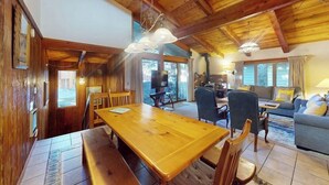 A wooden interior with a dining table, chairs, a sofa, and a fireplace. - Central Condo w/ Fireplace & Shared Pool/Hot Tub/Tennis - 1 Mile to Gondola (Mammoth Lakes)