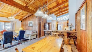 A wooden interior with a dining table, chairs, a sofa, and a kitchen area. - Central Condo w/ Fireplace & Shared Pool/Hot Tub/Tennis - 1 Mile to Gondola (Mammoth Lakes)