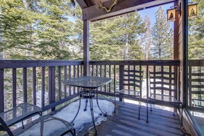A wooden deck with a table and chairs, surrounded by a wooden railing, overlooking a forested area. - Val d'Isere #45, 350 yards to Village Gondola, with garage and forest deck (Mammoth Lakes)