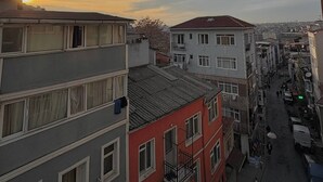 Um edifício com várias andares, varandas e vista para a rua.