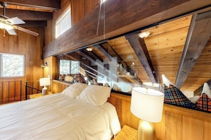 Ein Schlafzimmer mit Bett, Lampe, Fenster und Deckenventilator.