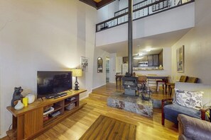 Ein großzügiger Wohnbereich mit Fernseher, Holz-Entertainment-Möbel und Kamin.