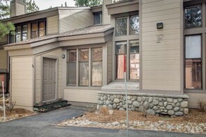 Ein modernes, zweistöckiges Haus mit Natursteinfassade, einer Garage und einer Veranda.