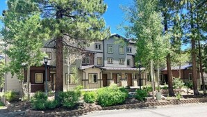 A multi-story residential building with a front porch, surrounded by trees and landscaping. - Convenient mountain getaway with views & on-site golf - near skiing (Mammoth Lakes)