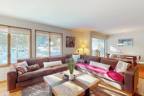 A living room with a sectional sofa, a coffee table, and a lamp. - Updated townhome with a fireplace, grill, pool, hot tub - easy access to slopes (Mammoth Lakes)