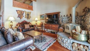 Un salon chaleureux avec une cheminée, un canapé en cuir, une table basse en bois et des éléments décoratifs en pierre.