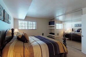 Une chambre à coucher avec un lit, une télévision, une armoire et une fenêtre.