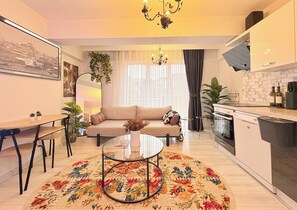 A modern living room with a sofa, coffee table, and dining area. - Bright & Modern 2BR Apartment in Kağıthane (Istanbul)
