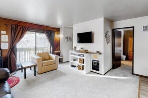 Ein Wohnzimmer mit einer Couch, einem Fernseher und einem Kamin.