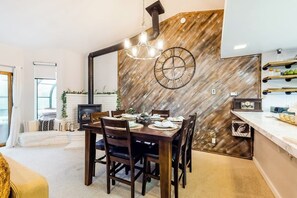 Spiseområde med trævæg, lysekrone og et ur.