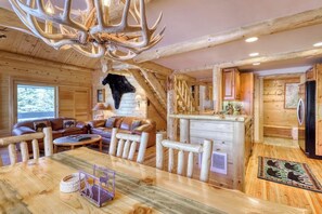 Ein Blockhaus-Interieur mit Essbereich, Kamin und Küche.