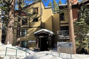 A multi-story building with a covered entrance, snow on the ground, and a sign indicating it's a Fireside Lodge. - Charming mountain condo w/ shared pool, hot tub, & easy slope access (Mammoth Lakes)