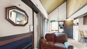 A living room with a fireplace, a large mirror, and a sofa. - Contemporary condo near The Village with easy slope access, balcony & hot tub (Mammoth Lakes)