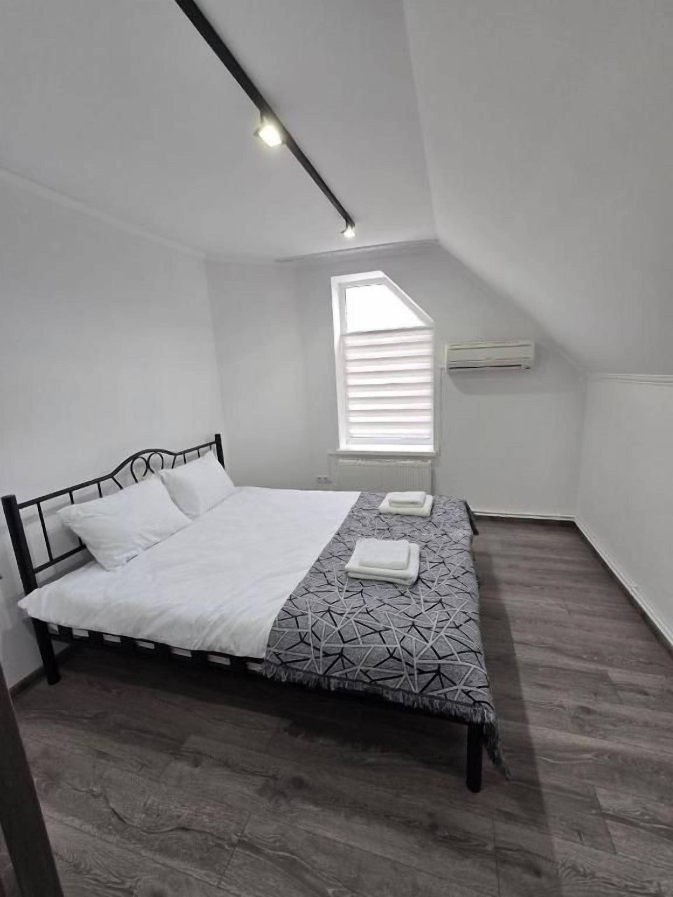 A bedroom with a bed, a window, and a radiator.