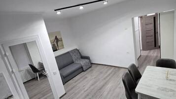 A modern interior with a dining area, a sofa, and a kitchen.