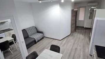 Une cuisine moderne avec un coin repas, un canapé et une table avec des chaises.