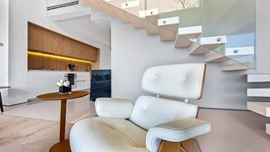 Ein modernes Interieur mit einer Couch, einem runden Tisch und einer Treppe.