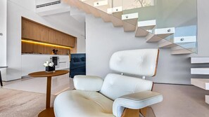 Un interior moderno con un sofá, una mesa redonda y una escalera.